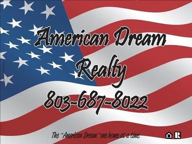 Sign with an American flag background displaying "American Dream Realty" and a phone number, "803-687-8022." The bottom of the sign reads, "The 'American Dream' one home at a time" with a house icon.